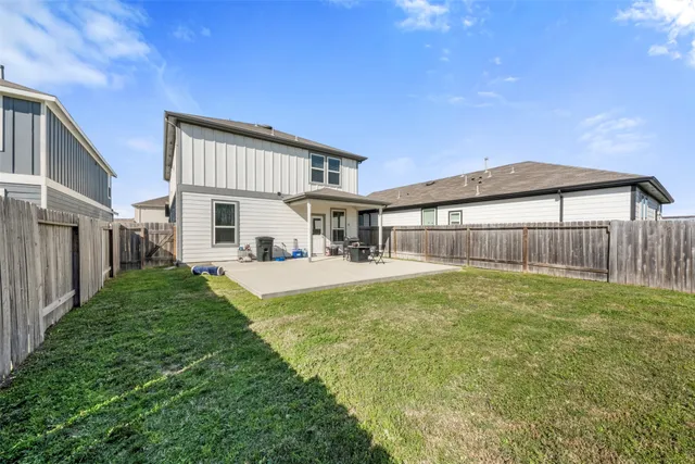 a view of a house with backyard and a tree