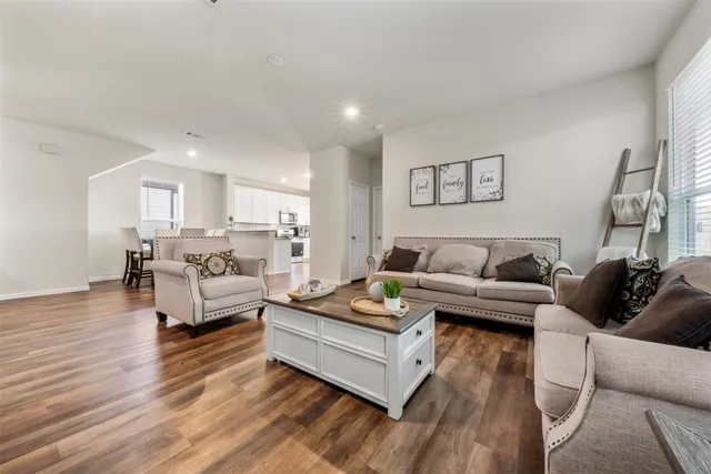 a living room with furniture and a wooden floor