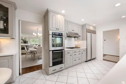 a kitchen with white cabinets and stainless steel appliances