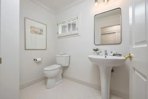 a bathroom with a toilet sink and mirror