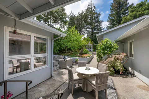 a view of a patio with table and chairs and potted plants
