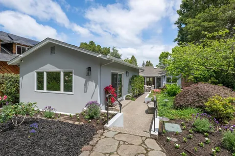 a front view of a house with a yard and potted plants