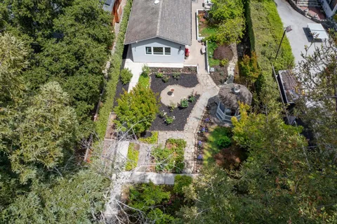 an aerial view of a house with a yard and trees