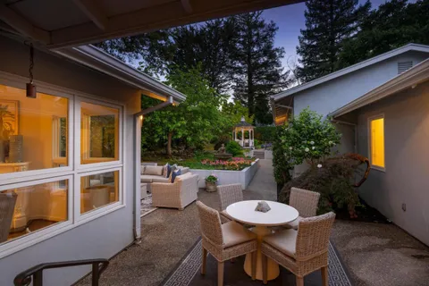 a backyard of a house with table and chairs