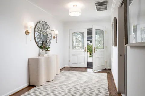 a view of a hallway with entryway wooden floor and front door