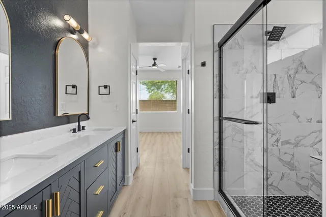 a bathroom with a double vanity sink a large mirror and shower