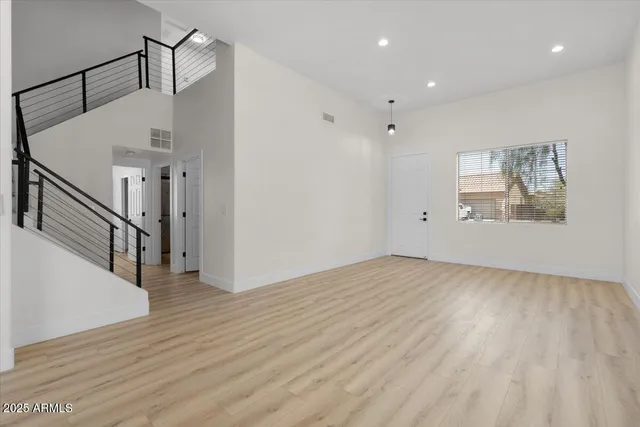 a view of a livingroom with wooden floor and stairs