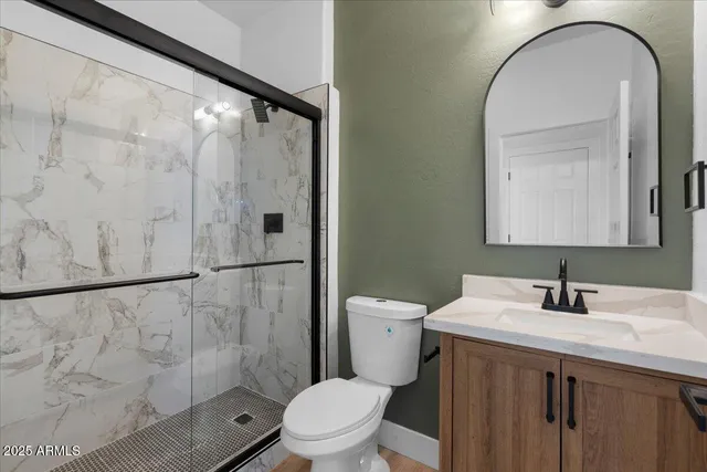 a bathroom with a granite countertop sink toilet and shower
