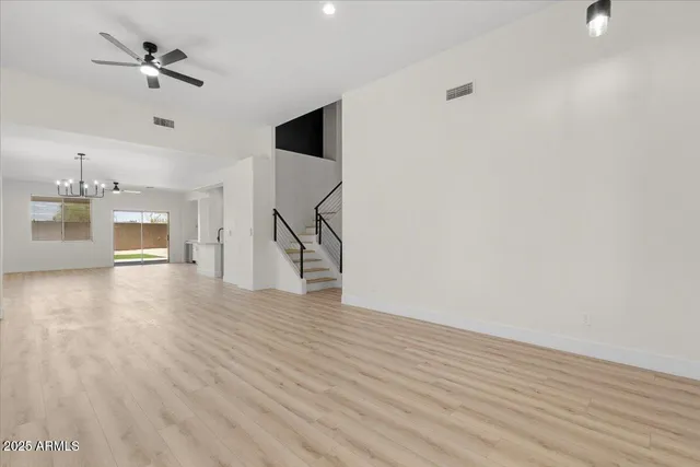 a view of a livingroom with wooden floor and a ceiling fan
