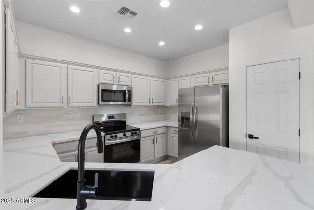 a kitchen with a refrigerator a microwave and white cabinets
