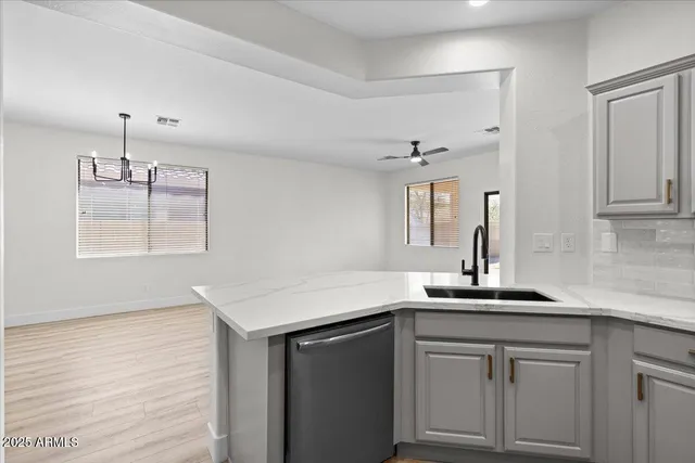 a kitchen with a sink dishwasher and white cabinets