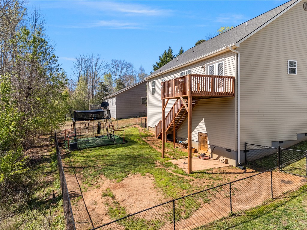 2520 Linmar Circle Anderson, SC 29621 - Photo 38 of 50 A tiered wood deck overlooks a fenced backyard with mature trees, perfect for outdoor recreation.