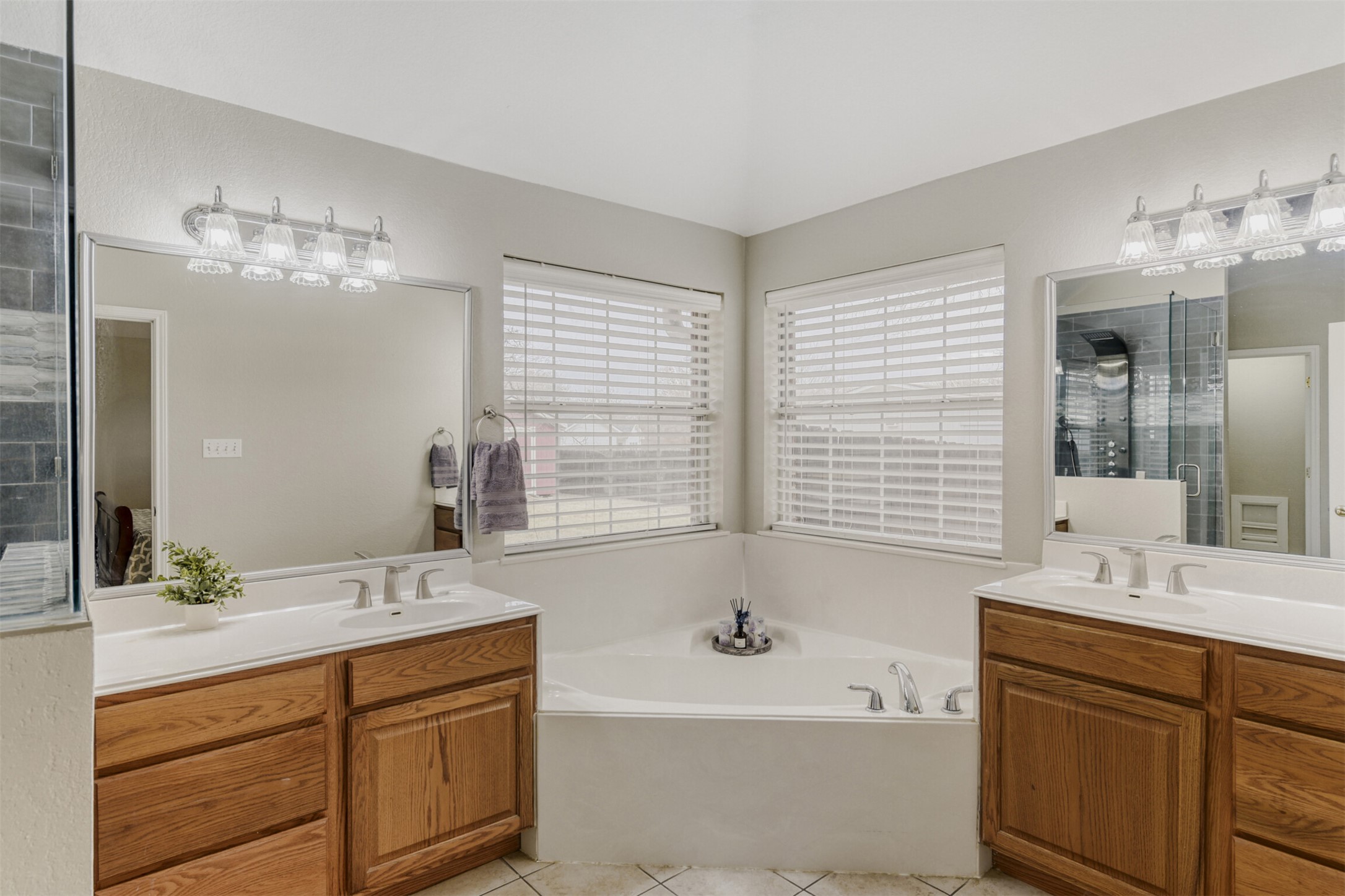 104 Spring Branch Bastrop, TX 78602 - Photo 24 of 32 Bathroom with two vanities, a garden tub, light tile patterned floors, and an enclosed shower