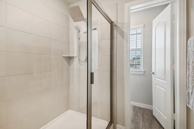 a bathroom with a shower and a glass door