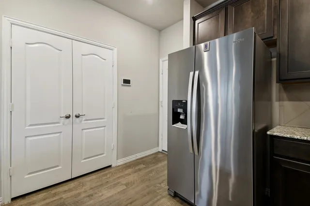 a view of a refrigerator in kitchen and white cabinets