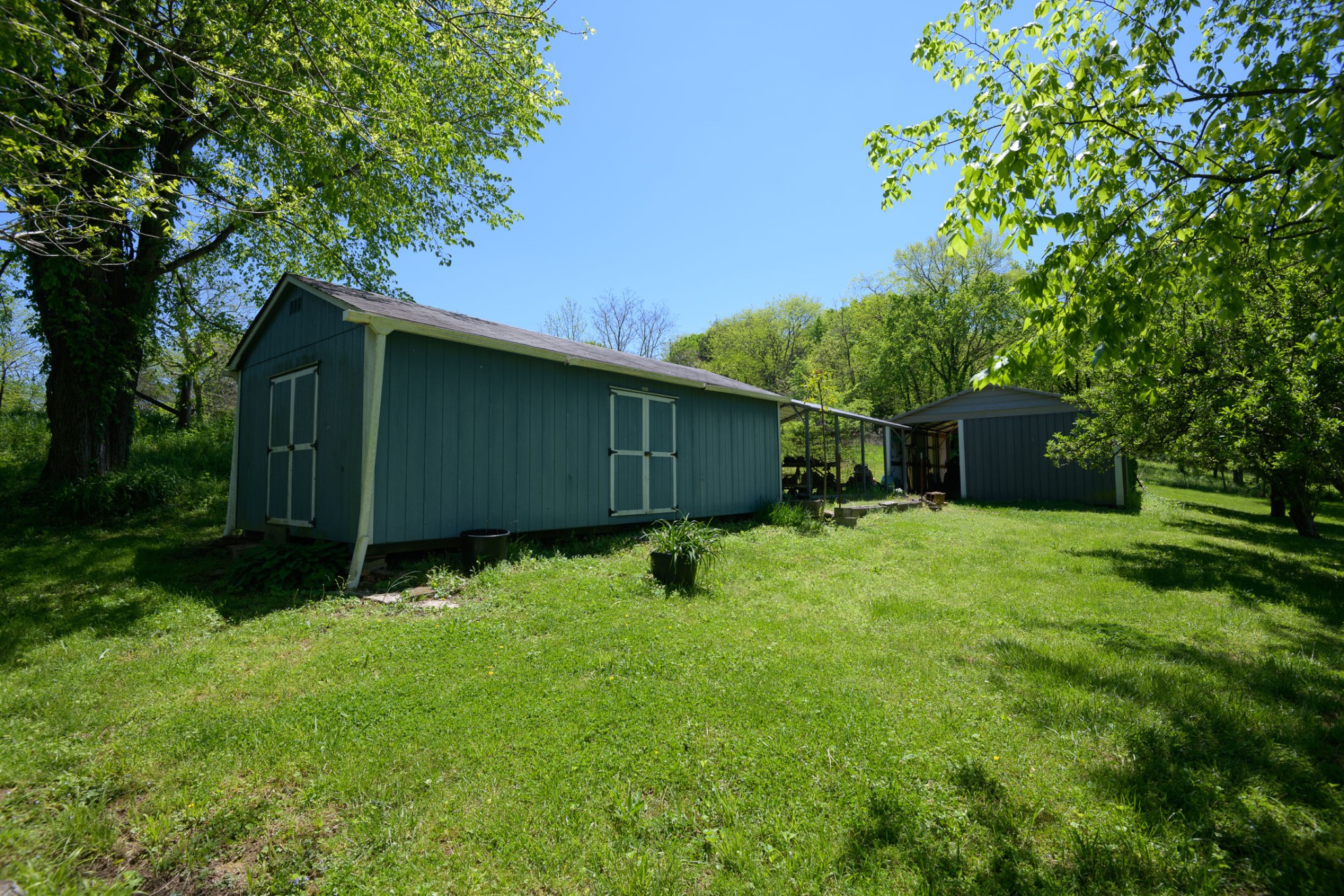 4496 Lower Helton Road Alexandria, TN 37012 - Photo 25 of 40 a backyard of a house with lawn chairs plants and tree
