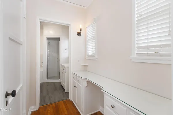 a hallway with white cabinets and wooden floor