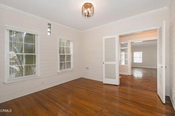 a view of an empty room with a window and wooden floor