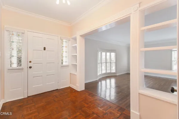 a view of a bedroom with wooden floor and windows