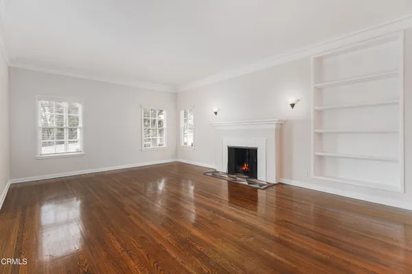 a view of empty room with wooden floor and fireplace