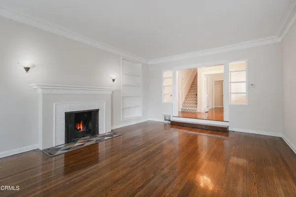 a view of empty room with wooden floor and fireplace
