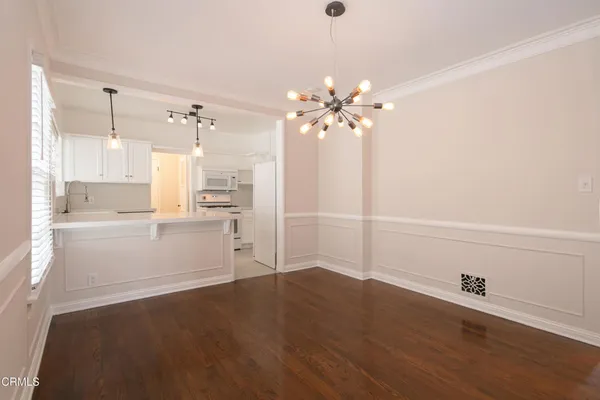 a view of a kitchen with wooden floor and a kitchen space