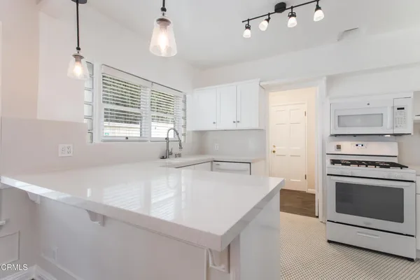 a kitchen with a stove a sink and a refrigerator