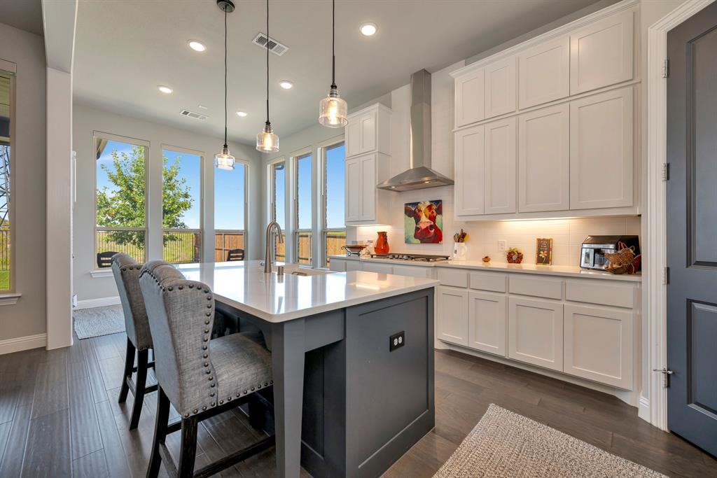 1129 Highpoint Way Roanoke, TX 76262 - Photo 14 of 26 a kitchen with granite countertop a table chairs sink and cabinets