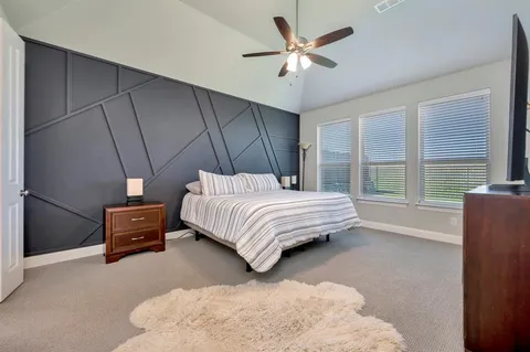 a bedroom with a bed and a large window