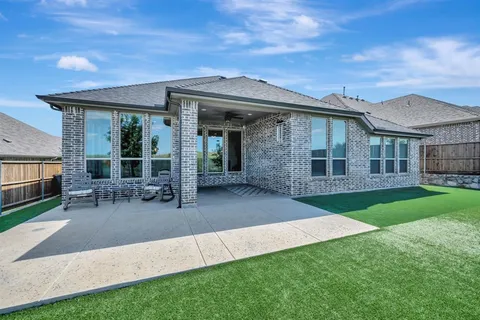 a view of a house with a big yard plants and large trees