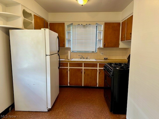 751 Thayer Street, Unit DOWN Akron, OH 44310 - Photo 7 of 25 Kitchen with black gas range, white refrigerator, sink, and tasteful backsplash