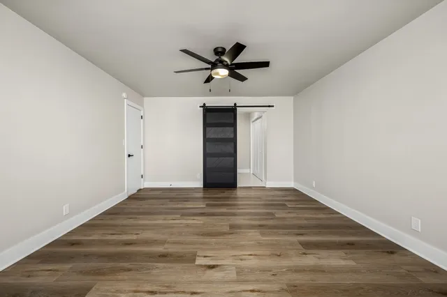 a view of a kitchen with wooden floor and a ceiling fan