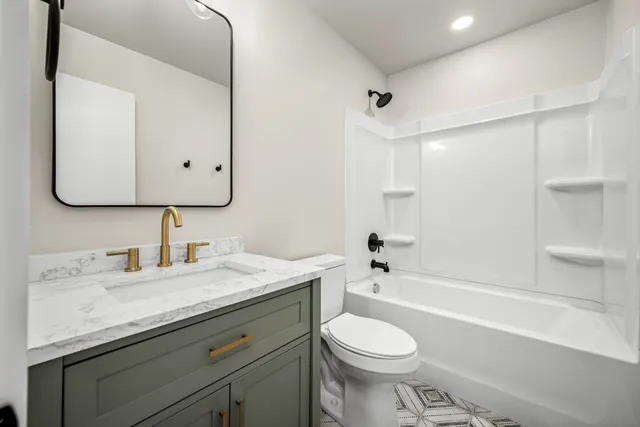 a bathroom with a granite countertop sink toilet and shower