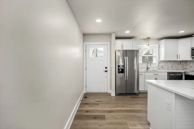 a view of a kitchen with a refrigerator and a stove top oven