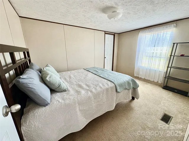 a bedroom with a bed and a large window