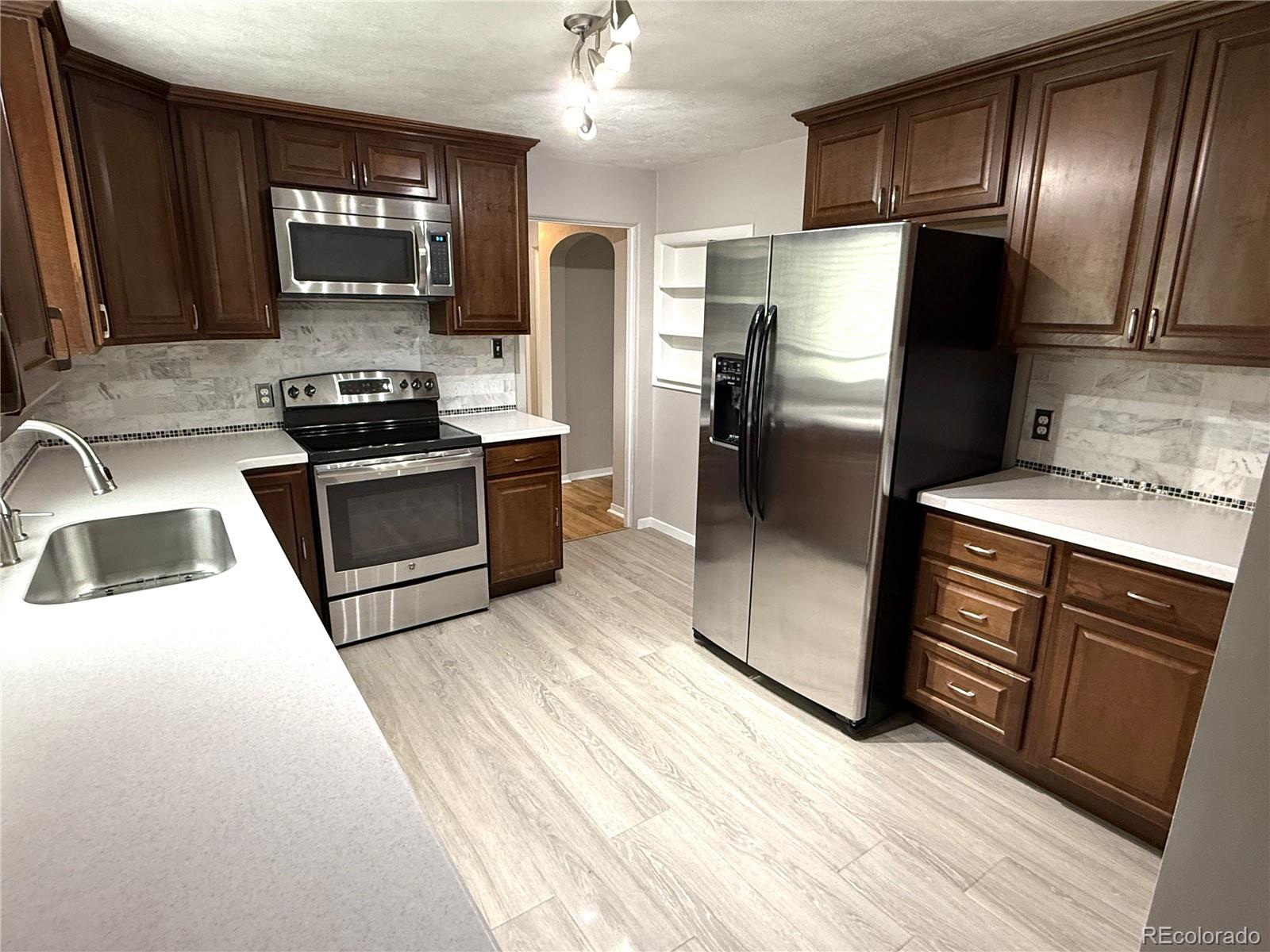1920 Willow Street Denver, CO 80220 - Photo 19 of 41 a kitchen with stainless steel appliances granite countertop a refrigerator stove and sink
