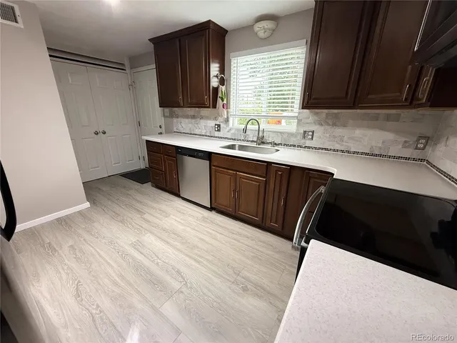 a kitchen with a sink a stove and cabinets