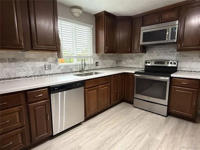 a kitchen with stainless steel appliances granite countertop a sink stove and microwave