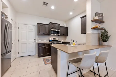 a kitchen with stainless steel appliances a stove a sink dishwasher a refrigerator and a oven with wooden floor