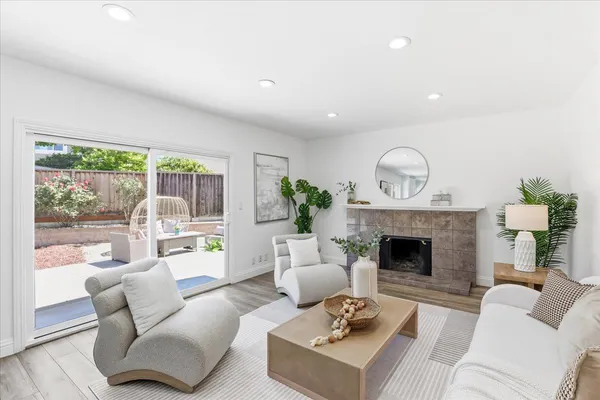 a living room with furniture a fireplace and a potted plant