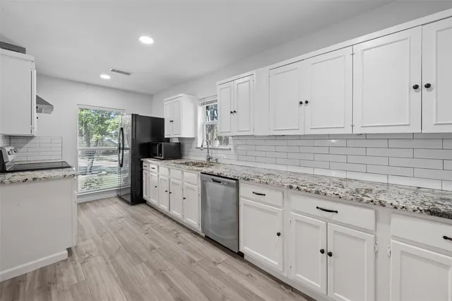 a kitchen with a stove a sink dishwasher a refrigerator and a microwave