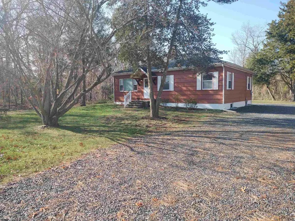 a view of a yard in front of a house with large trees