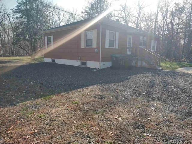 a view of a yard in front of a house with large trees