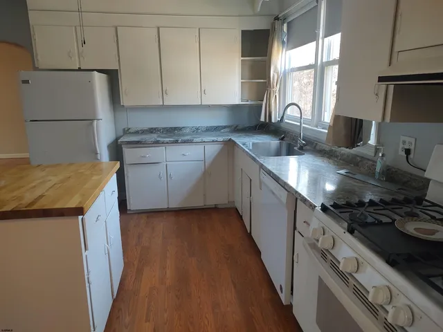 a kitchen with granite countertop a sink and a stove next to a window