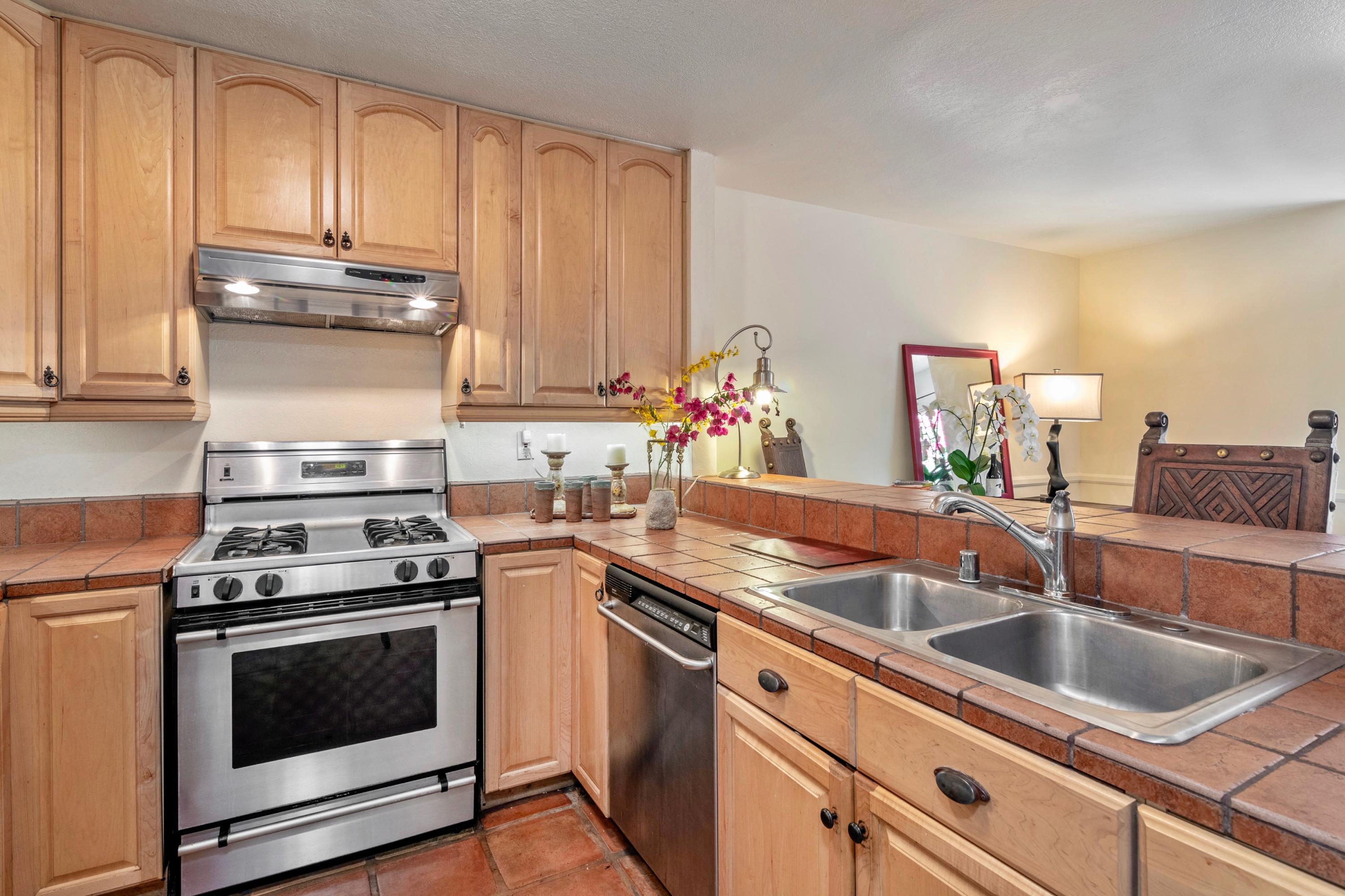 415 West Gutierrez Street, Unit 16 Santa Barbara, CA 93101 - Photo 3 of 12 a kitchen with granite countertop a sink stove and cabinets