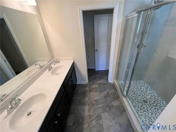 a bathroom with double vanity and a mirror