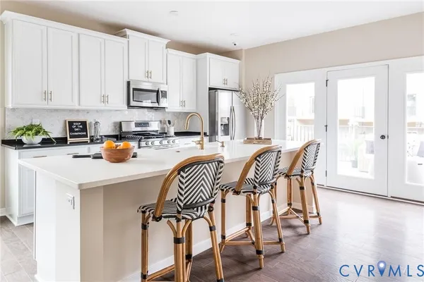 a kitchen with a table chairs cabinets and appliances