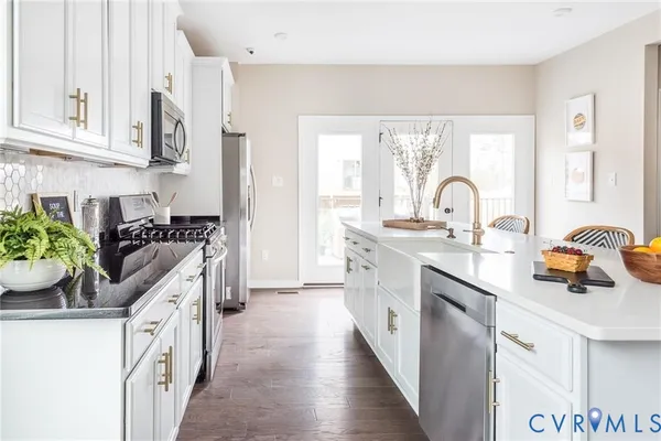 a kitchen with stainless steel appliances a sink stove and cabinets