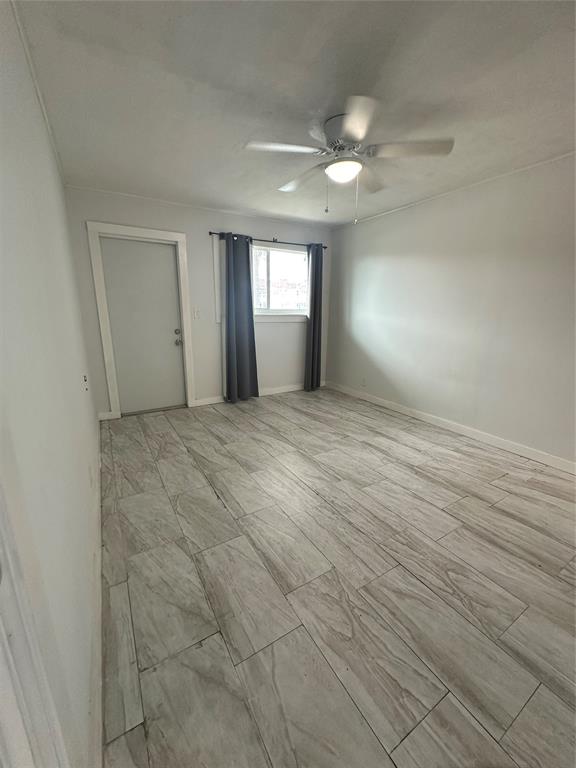 2175 Northeast 56th Street, Unit 106 Fort Lauderdale, FL 33308 - Photo 20 of 20 an empty room with wooden floor and windows