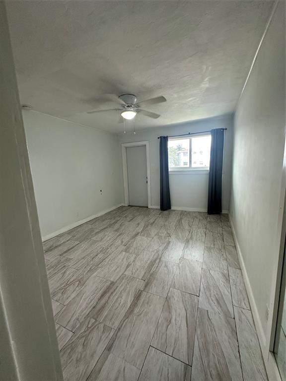 2175 Northeast 56th Street, Unit 106 Fort Lauderdale, FL 33308 - Photo 7 of 20 wooden floor in an empty room with a window